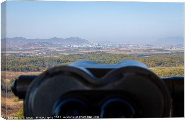 A view into North Korea across the DMZ from South Korea, from behind binoculars Canvas Print by SnapT Photography