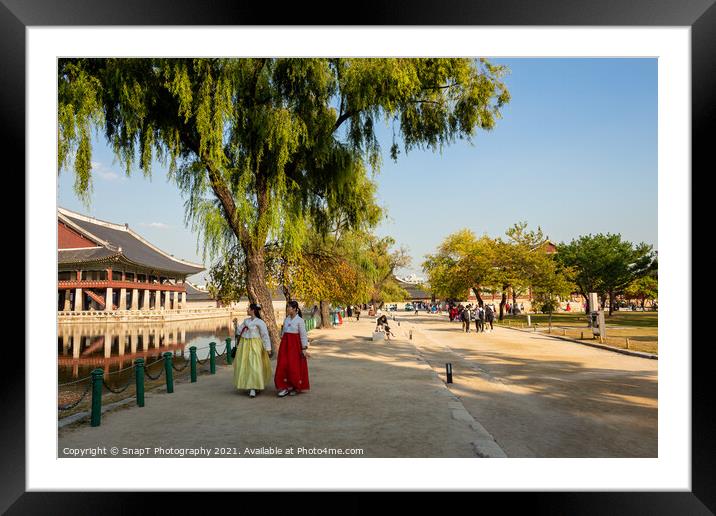 Two women in hanboks walking beside the lake at Gyeongbokgung Palace, Seoul Framed Mounted Print by SnapT Photography