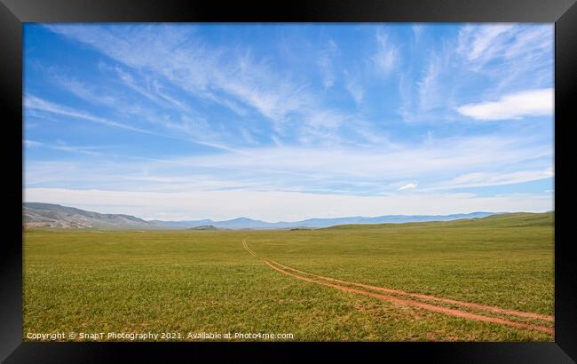 A track across a Mongolian grassland with mountains in the background Framed Print by SnapT Photography