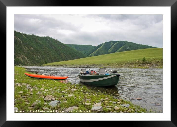 A fishing raft and kayak anchored on grass bank beside the river Framed Mounted Print by SnapT Photography
