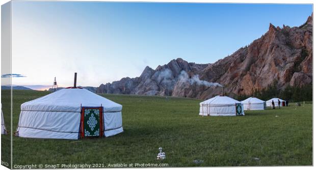 A row of Mongolian gers at a camp at sunset on a summers night, with chimney smoke Canvas Print by SnapT Photography