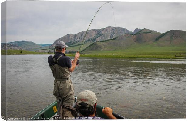 A fisherman with a Taimen Trout on the end of his line in Mongolia, Moron, Mongolia - July 14th 2014 Canvas Print by SnapT Photography