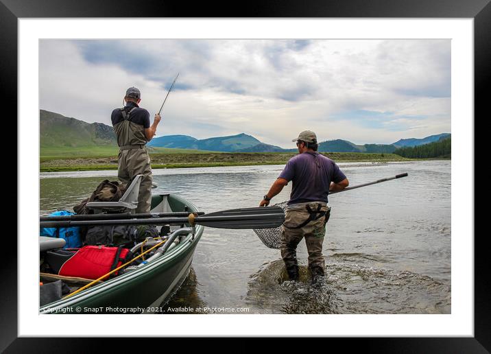 A fisherman with a Taimen Trout on the end of his line in Mongolia, Moron, Mongolia - July 14th 2014 Framed Mounted Print by SnapT Photography