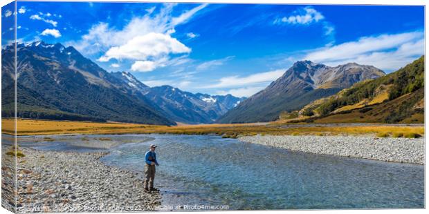 An Angler fly fishing for trout on the Ahuriri river, surrounded by mountains Canvas Print by SnapT Photography