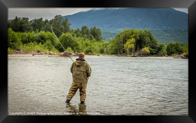 Fisherman battling a fish with a bent rod, while wading. Framed Print by SnapT Photography