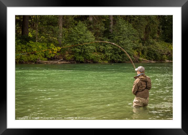 A man hooked into a fish while fly fishing on a deep green river. Framed Mounted Print by SnapT Photography