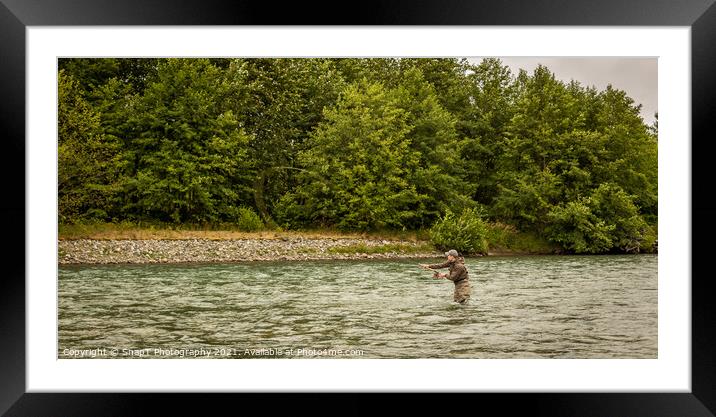 A fly fisherman spey casting while wading in a fast flowing, green, glacial river. Framed Mounted Print by SnapT Photography