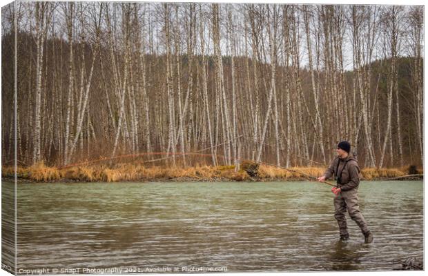 A fly fisherman hooked into a big fish in a river with the rod bent Canvas Print by SnapT Photography