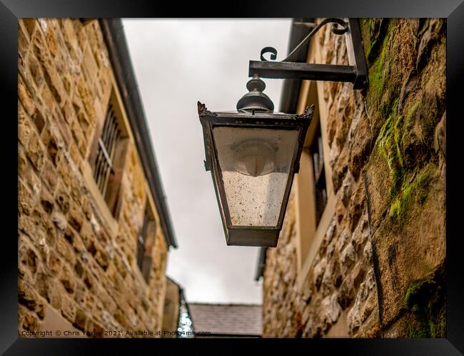 Victorian style light on an old and historic building in a narrow alley way Framed Print by Chris Yaxley