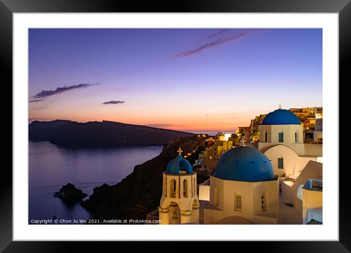 Blue domed churches and traditional white houses facing Aegean Sea with warm sunset light in Oia, Santorini, Greece Framed Mounted Print by Chun Ju Wu