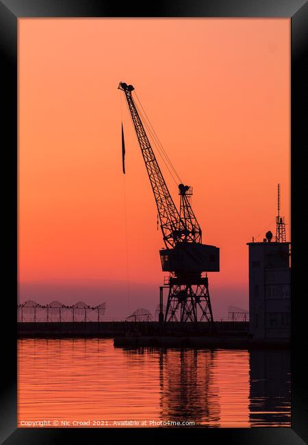 Port crane at sunset Framed Print by Nic Croad