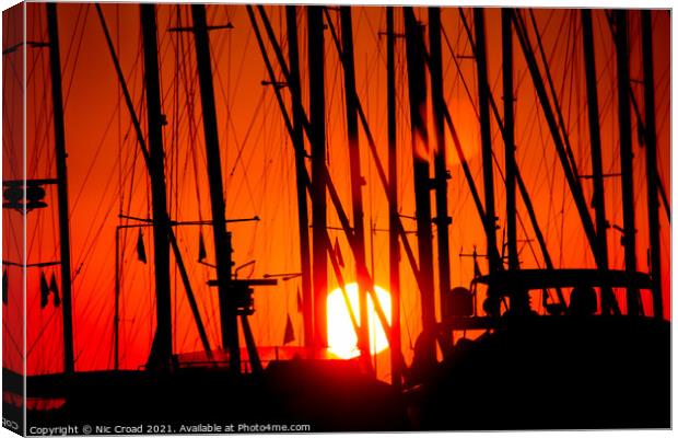 Sunset through silhouetted yacht masts Canvas Print by Nic Croad