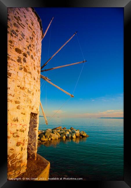 Greek windmill on the beach Framed Print by Nic Croad