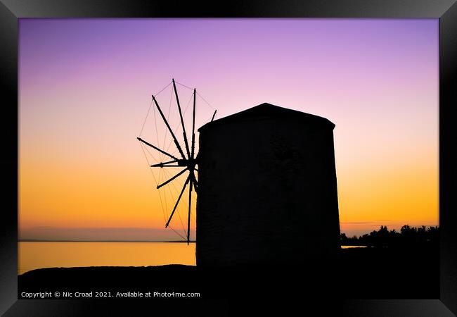 Silhouette of a Greek windmill at sunset Framed Print by Nic Croad