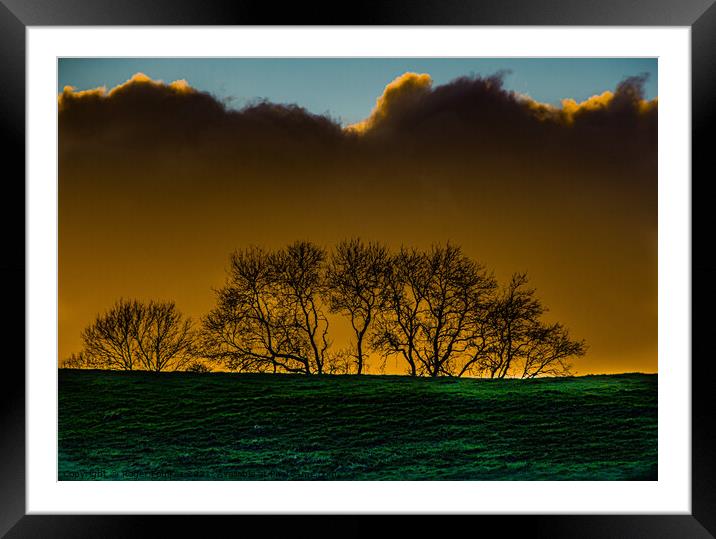 Moody SkylineA large green field in front of a sunset Framed Mounted Print by Roger Foulkes