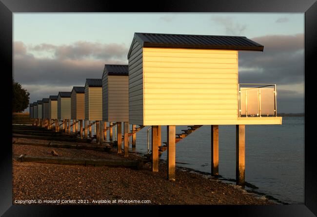 Osea Beach Huts towards dusk Framed Print by Howard Corlett