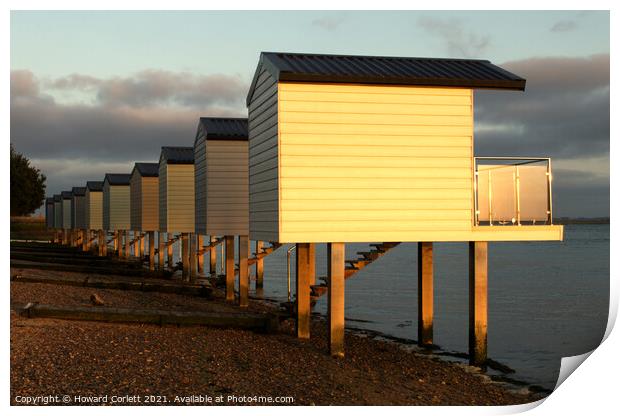Osea Beach Huts towards dusk Print by Howard Corlett