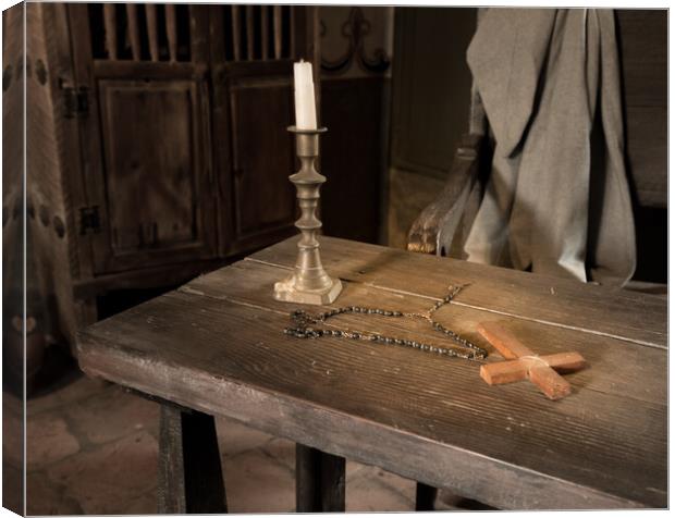 Ancient table with candle, rosary and cross in priest room Canvas Print by Steve Heap