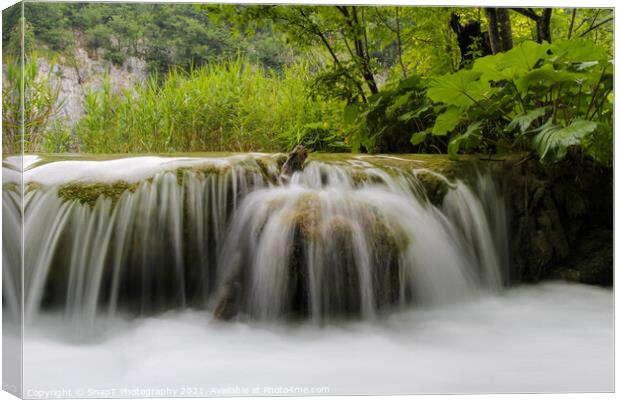 Long exposure of water flowing over a small waterfall at Plivice Lakes, Croatia Canvas Print by SnapT Photography
