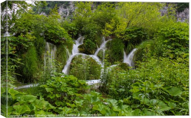 Water flowing through vegetation and over a waterfall at Plitvice Lakes Canvas Print by SnapT Photography