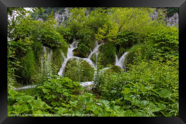 Water flowing through vegetation and over a waterfall at Plitvice Lakes Framed Print by SnapT Photography