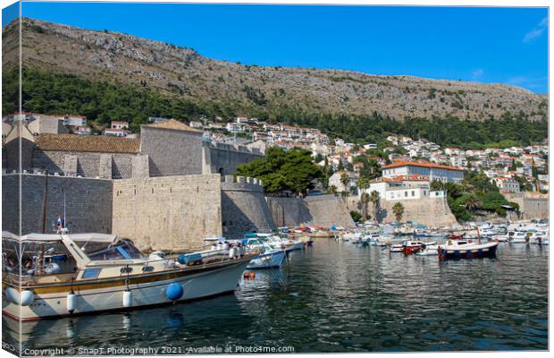 Boats moored in Dubrovnik Harbour by the city walls of the old town, Croatia Canvas Print by SnapT Photography