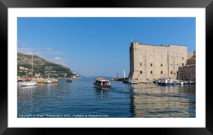 A boat leaving Dubrovnik harbour by the maritime museum in the old town, Croatia Framed Mounted Print by SnapT Photography