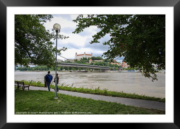 People walking along a footpath by the River Danube with the Bratislava Castle Framed Mounted Print by SnapT Photography