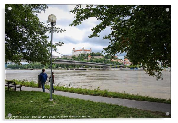 People walking along a footpath by the River Danube with the Bratislava Castle Acrylic by SnapT Photography