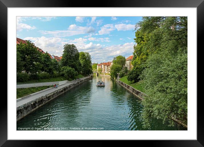A tourist boat travelling along the Ljublijanica River in afternoon in Ljubljana Framed Mounted Print by SnapT Photography