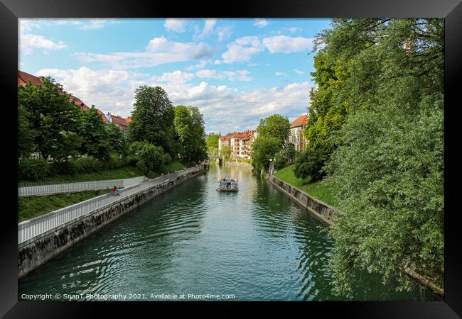 A tourist boat travelling along the Ljublijanica River in afternoon in Ljubljana Framed Print by SnapT Photography