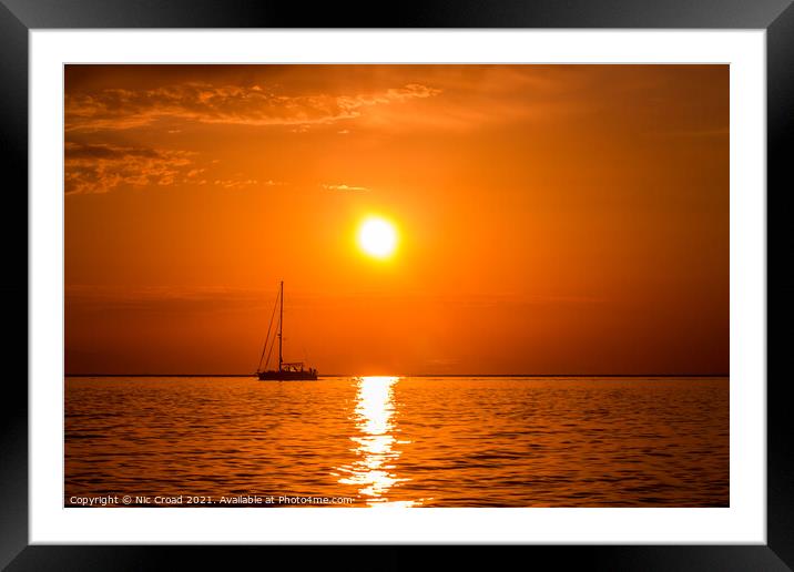Yacht on the sea at sunset Framed Mounted Print by Nic Croad