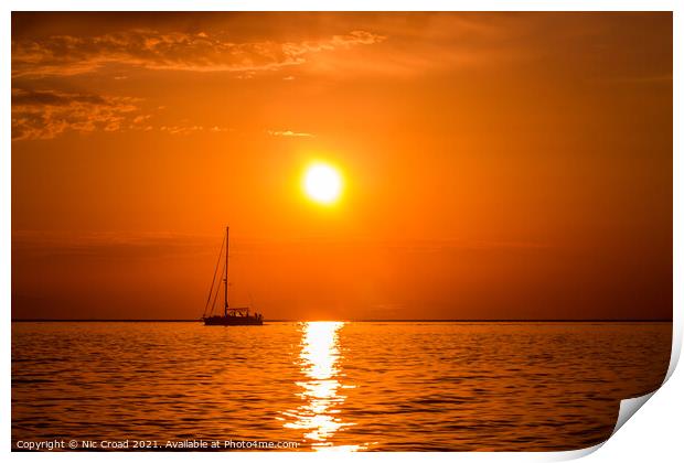 Yacht on the sea at sunset Print by Nic Croad