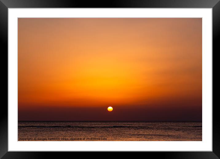 Bright sunset with a big yellow sun under the sea surface. Framed Mounted Print by Sergey Fedoskin