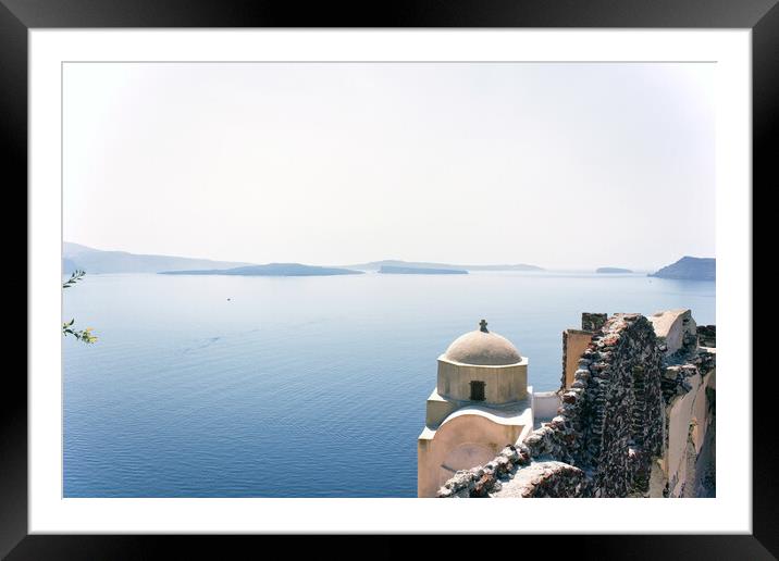 Santorini, Greece - September 11, 2017: Wide angle view of typical Church dome in Firostefani village and sea view with mountains in oia region against mediterranean sea. Framed Mounted Print by Arpan Bhatia