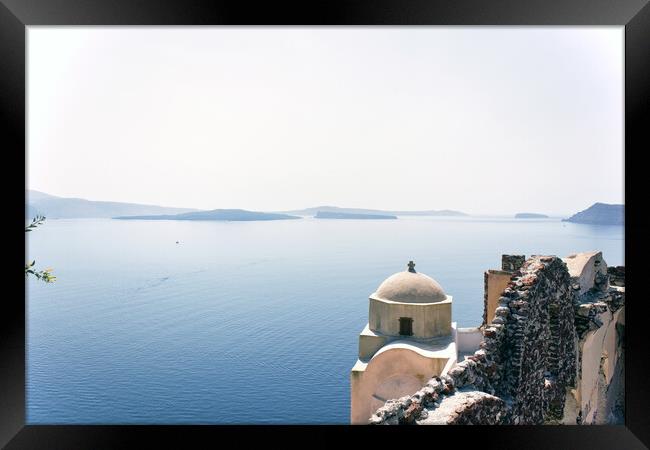 Santorini, Greece - September 11, 2017: Wide angle view of typical Church dome in Firostefani village and sea view with mountains in oia region against mediterranean sea. Framed Print by Arpan Bhatia