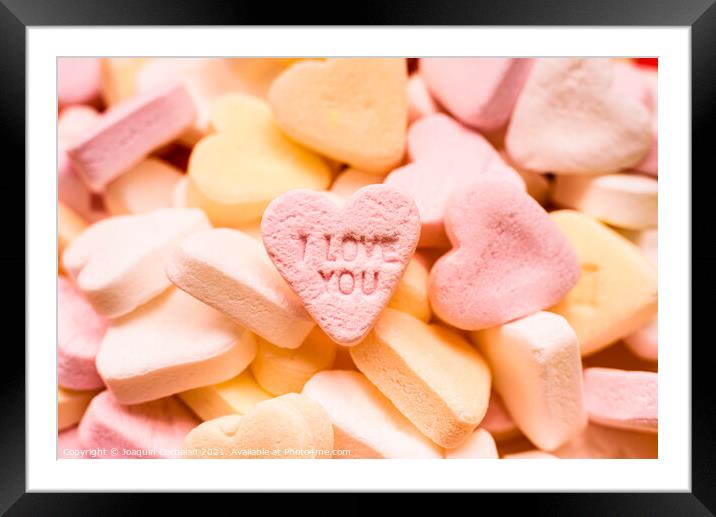 Love word engraved in a sweet romantic heart-shaped candy to giv Framed Mounted Print by Joaquin Corbalan