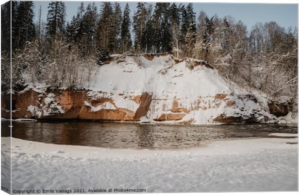 rock cliff and cave by the river Gauja in the Gauja National Park in Latvia in winter with beautiful sun through the forest Canvas Print by Emils Vanags