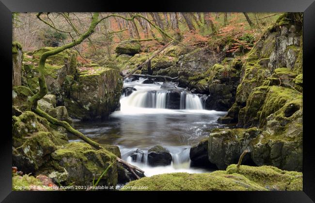 A small waterfall over a rocky cliff Framed Print by Barclay Brown