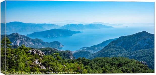Panoramic  view of turquoise sea and mountains Canvas Print by Stuart Chard