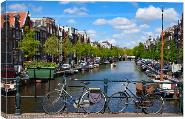Bikes on the bridge that crosses the canal in Amsterdam, Netherlands Canvas Print by Chun Ju Wu