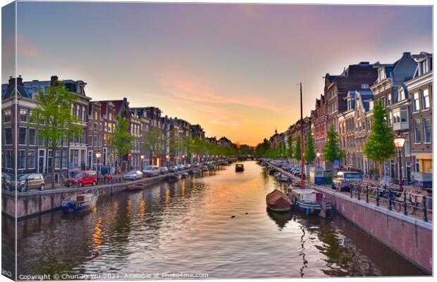 Buildings and boats along the canal at sunset time in Amsterdam, Netherlands Canvas Print by Chun Ju Wu