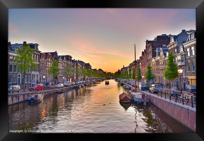 Buildings and boats along the canal at sunset time in Amsterdam, Netherlands Framed Print by Chun Ju Wu