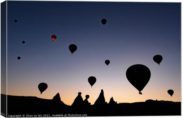 Silhouette of flying hot air balloons and rock landscape at sunrise time in Goreme, Cappadocia, Turkey Canvas Print by Chun Ju Wu