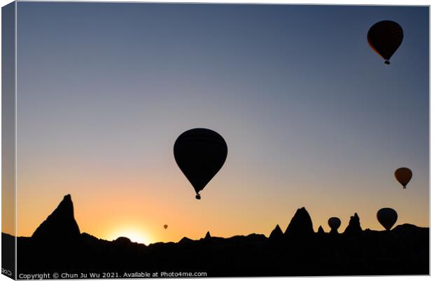 Silhouette of flying hot air balloons and rock landscape at sunrise time in Goreme, Cappadocia, Turkey Canvas Print by Chun Ju Wu
