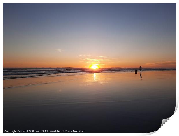 Silhouetted couple enjoys sunset at beach 2 Print by Hanif Setiawan