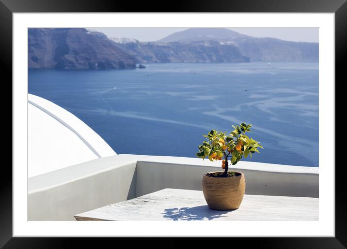 Santorini, Greece: A pot with flower or plant and a plate on a wooden table against beautiful sea ocean background Framed Mounted Print by Arpan Bhatia