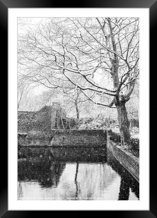 snow covered tree over moat Framed Mounted Print by Sara Melhuish