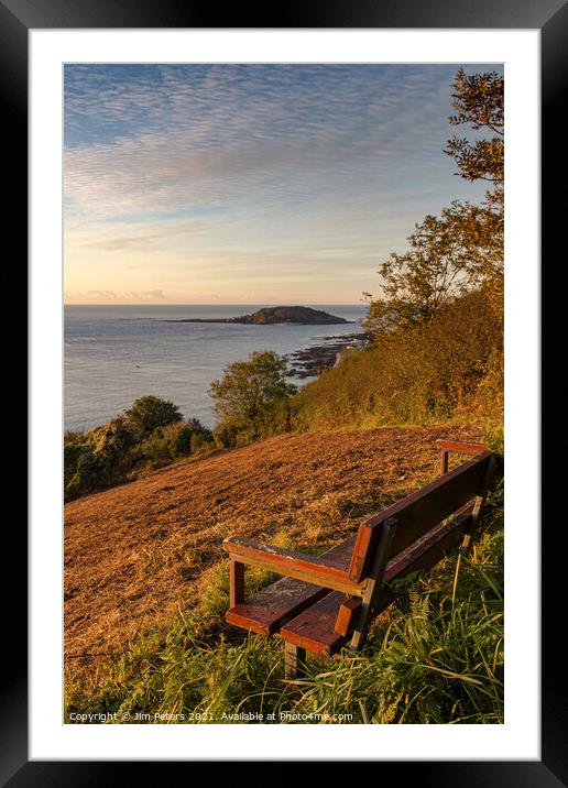 Wooden bench overlooking Looe bay & Looe island in the early morning sun Framed Mounted Print by Jim Peters