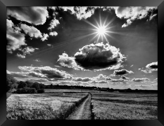 Sun bursting through clouds, black and white. Framed Print by mark humpage